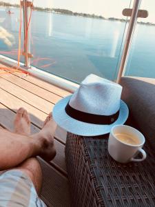 a man with a hat and a cup of coffee at Hausboot Elandi in Bitterfeld
