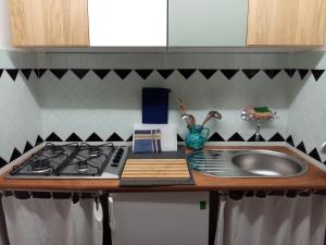 a kitchen counter with a sink and a stove at Laetitia in Porto Santo Stefano