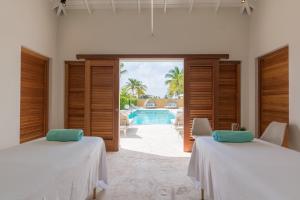 two beds in a room with a view of the pool at Dolphin Suites & Wellness Curacao in Willemstad