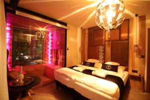 1 dormitorio con 1 cama grande con luces rosas en Baobab Suites, en Siófok