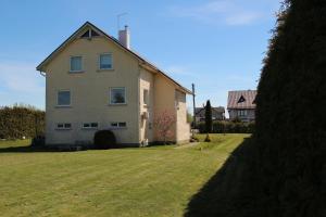 uma casa grande com um jardim de relva em frente em Dangus em Ramučiai