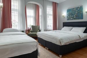 a bedroom with two beds and a chair and windows at Dualis Hotel in Istanbul