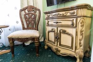 a dresser and a chair next to a television at Charlino Plaza in Ruse