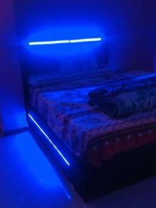 a bed in a room with a blue light at Sweet Home- No Egyptian in Hurghada