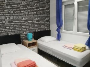 dwa łóżka w pokoju ze ścianą z pismem w obiekcie VILLA DOS-LAGOS w mieście Torrevieja