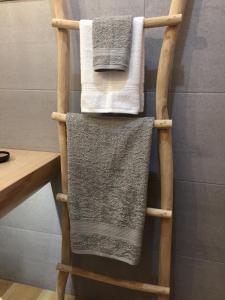 a bamboo towel rack with three towels on it at Domek Góralski u Basisty in Poronin