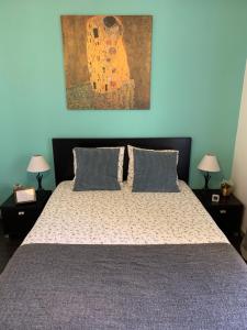 a bedroom with a bed and a painting on the wall at Casa Flor de Lis - T2 CENTRO in Braga