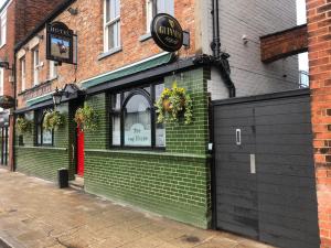 un edificio de ladrillo verde con un cartel. en Bay horse hotel en Selby