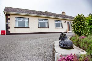 a statue of a dog sitting in front of a house at The Rock Equestrian Farm B&B in Bailieborough
