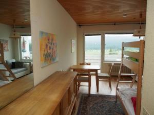 een woonkamer met een tafel en een stapelbed bij Mountain View Apartment in Bad Mitterndorf