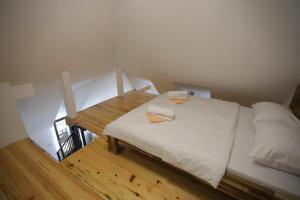 Schlafzimmer mit einem weißen Bett und einem Holztisch in der Unterkunft P-ZLATAR, apartman 3 in Brdo