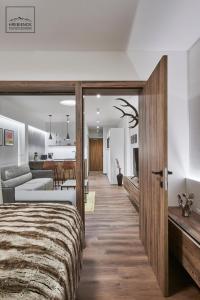 a bedroom with a large bed and a living room at HREBIENOK MOUNTAIN APARTMENTS STARÝ SMOKOVEC in Smokovce