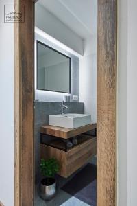 a bathroom with a white sink and a mirror at HREBIENOK MOUNTAIN APARTMENTS STARÝ SMOKOVEC in Smokovce