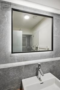 La salle de bains est pourvue d'un miroir et d'un lavabo. dans l'établissement HREBIENOK MOUNTAIN APARTMENTS STARÝ SMOKOVEC, à Starý Smokovec