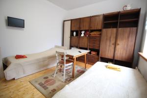 1 dormitorio con 1 cama, 1 mesa y 1 cama en Dangus, en Ramučiai