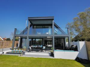 een glazen huis met een zwembad en een tafel bij Oyster Shell Whitstable in Whitstable