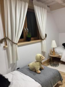 un orsacchiotto seduto su un letto in una camera da letto di Domek Góralski u Basisty a Poronin