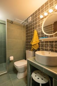 a bathroom with a sink and a toilet and a mirror at SaltHouse #2 in Kalabaka