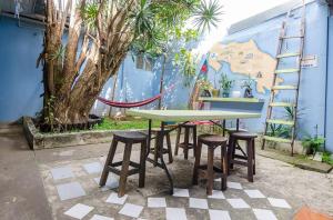 a table and stools in front of a wall at In the Wind Hostel and Guesthouse in San José