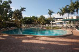 a large swimming pool in a resort with palm trees at Riverside Hotel in Fort Lauderdale