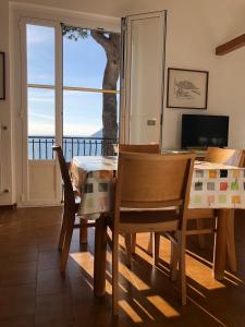 uma sala de jantar com uma mesa e cadeiras e uma janela em Appartamenti La Pineta em Marina dʼAndora