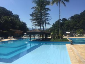 a swimming pool with a gazebo and palm trees at Casa Verde e Mar in Angra dos Reis