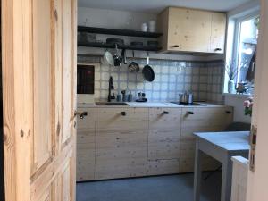 cocina con armarios de madera, mesa y ventana en Bremerraumnatur en Bremen