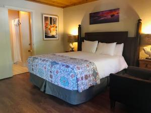 
a hotel room with a bed, chair, and nightstand at Fernwood Resort in Big Sur
