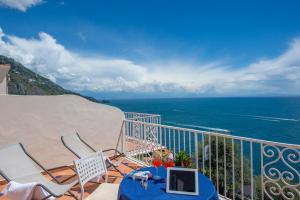 balcón con mesa, sillas y vistas al océano en Open Gate, en Praiano