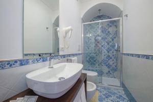 een badkamer met een wastafel, een douche en een toilet bij Open Gate in Praiano