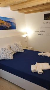 sypialnia z niebieskim łóżkiem i ręcznikami na nim w obiekcie Relax house w Cefalù