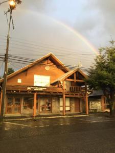 un arco iris en el cielo sobre un edificio en Pucontours Hostal, en Pucón