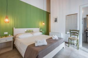 sypialnia z łóżkiem i zieloną ścianą w obiekcie Il Baiocco -Ibla Charme Rooms w mieście Ragusa