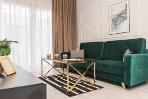 uma sala de estar com um sofá verde e uma mesa em Bed&Bath Luxury Apartments na Cracóvia