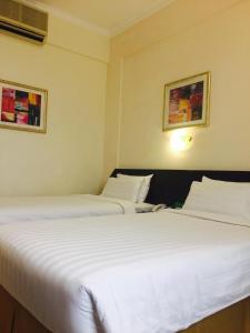 2 Betten nebeneinander in einem Zimmer in der Unterkunft Hotel Al Madinah Holiday in Muscat