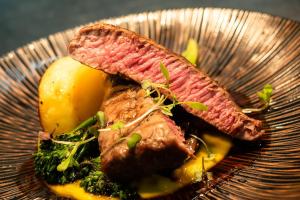a plate of food with meat and vegetables on a table at Peppers Cradle Mountain Lodge in Cradle Mountain