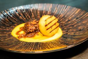 a plate of food with bananas and caramel sauce at Peppers Cradle Mountain Lodge in Cradle Mountain