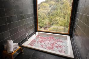 a bathroom with a bath tub filled with red peppers at Peppers Cradle Mountain Lodge in Cradle Mountain
