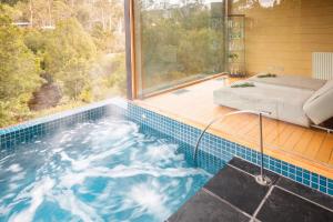 a jacuzzi tub in a house with a window at Peppers Cradle Mountain Lodge in Cradle Mountain