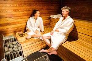 a man and a woman sitting in a sauna at Peppers Cradle Mountain Lodge in Cradle Mountain