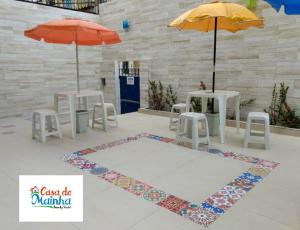 a room with tables and chairs and umbrellas at Casa de Mainha Friendly Hostel in Salvador