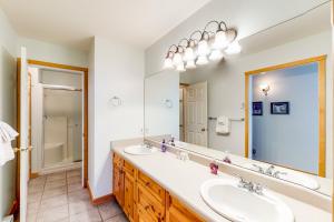 a bathroom with two sinks and a large mirror at DuHaus Green in Big White +16 photos