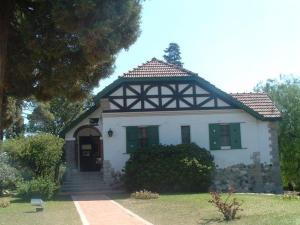 een klein wit huis met een zwart dak bij Saint Michel Departamentos para turismo in Alta Gracia