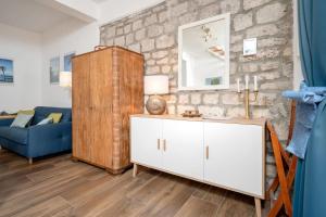 ein Wohnzimmer mit einem weißen Schrank und einem blauen Sofa in der Unterkunft House Heritage in Stari Grad