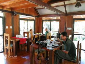 un hombre sentado en una mesa con una cámara en Surucua Reserva & Ecolodge en Comandante Andresito