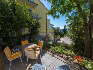 a patio with chairs and a table in front of a building at Apartments STIPE in Novi Vinodolski