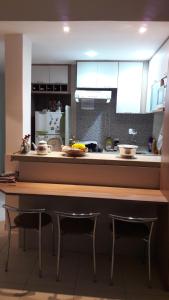 a kitchen with a wooden counter top with two chairs at Quarto e Sala completo in Rio de Janeiro