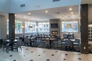 un ristorante con tavoli, sedie e un camino di Best Western PLUS Franklin Square Inn a Troy