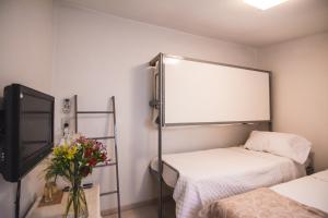 een kamer met 2 bedden en een flatscreen-tv bij LA PORTEÑA in Buenos Aires