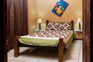 a bedroom with a bed in a room with two lamps at Las Calas Lodge in Bajos del Toro